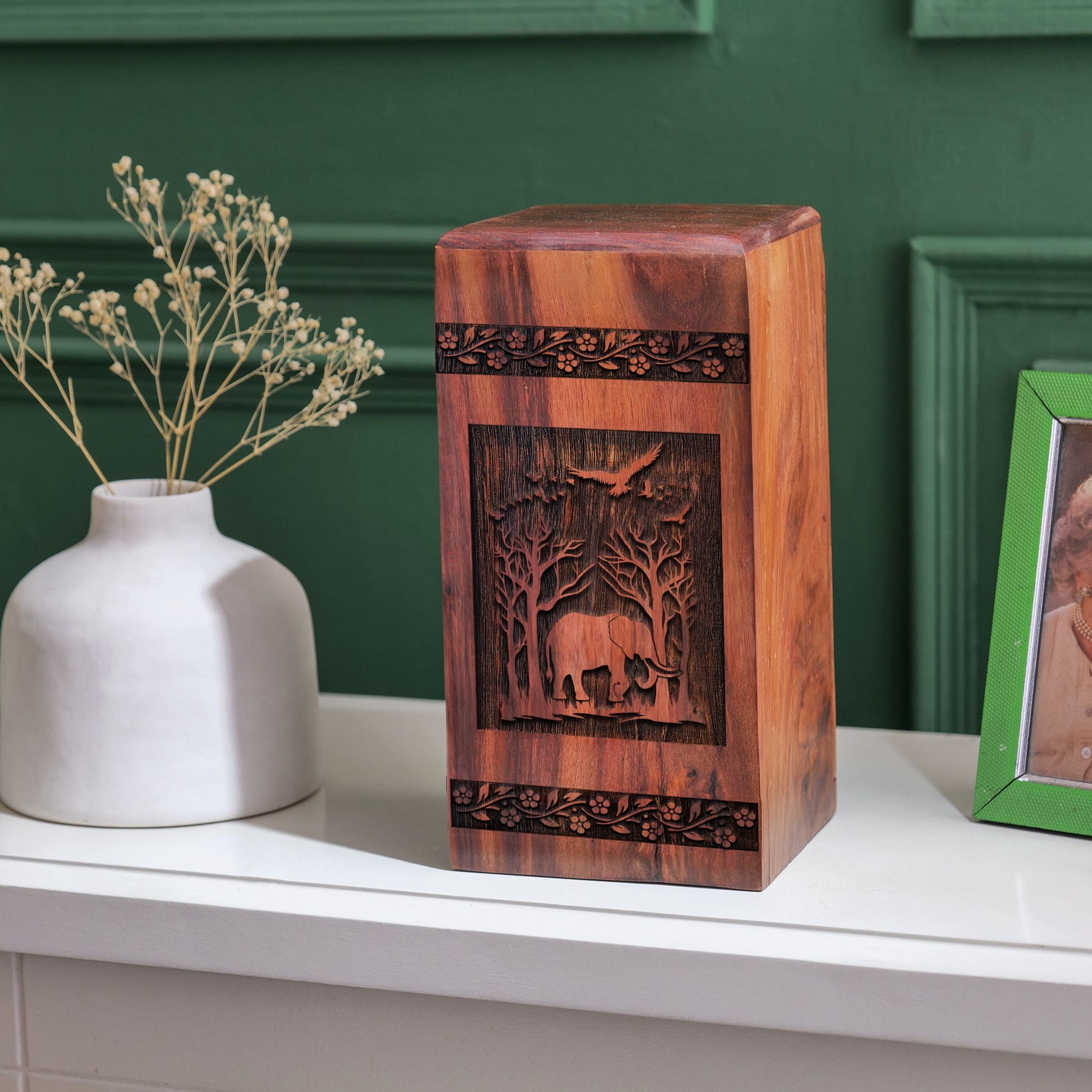 Large wooden urn featuring an elephant design, suitable for storing adult male human ashes.